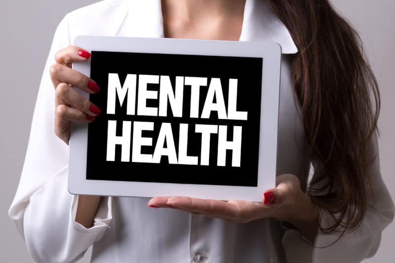 Woman holding a sign saying Mental Health
